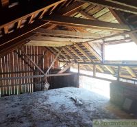 Attic space of a family house with roof beams and a window for lighting.