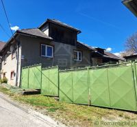 A family house in Heľpa with a large green gate on a sunny street.
