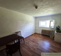 The interior of a family house with simple furniture and a wooden decor floor.