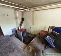 An old boiler room in a family house with office chairs and piping on the wall.