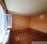 An open room with a wooden decor floor, a window with white curtains.