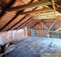Attic of a family house with wooden beams and brick walls.