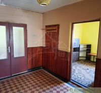 A room in a family house with tiles and furniture in the corner.