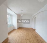 A bright room with an arched ceiling and a wooden decor floor in a three-room apartment.