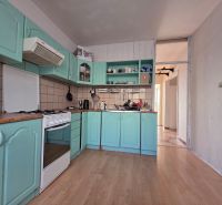 A kitchen with green cabinets and a wooden decor floor in a 4-room apartment.
