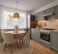 A kitchen in a 4-room apartment with a wooden decor floor and a round table.