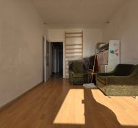 A room in a 4-room apartment with a wooden decor floor and green armchairs.