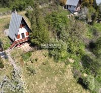 A cottage in Chyžné surrounded by greenery and nearby buildings, ideal for relaxation.