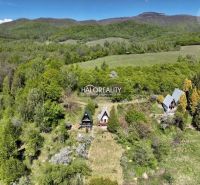 A cottage in Chyžné surrounded by forests and green meadows under a mountain panorama.