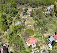 A cottage in Chyžné surrounded by greenery, situated in a spacious garden with surrounding trees.