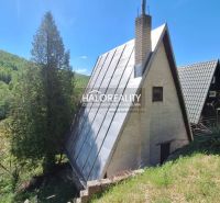 A cottage in Chyžné, surrounded by nature, with an interesting roof, trees and greenery in the vicinity.