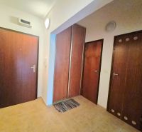 Hallway in a 2-room apartment with wooden doors and tiled floor.