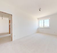 An empty room with white walls and a window in a newly built family house.