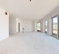 A family house with large windows and a view of the garden, white walls, light flooring.