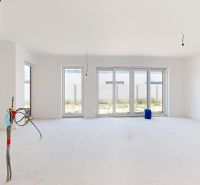 A spacious unfurnished interior of a family house with large windows.