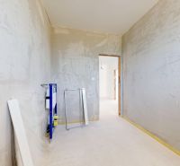 Unfinished interior with concrete walls and elements for sanitary installations in a family house.