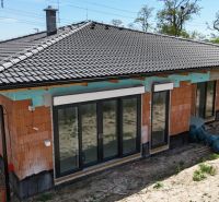A family house under construction in Bernolákovo with a ceramic roof and French windows.