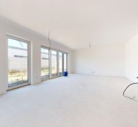A spacious room with large windows and neutral walls in a family house.