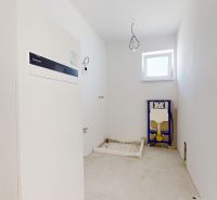 An empty room with a boiler and plumbing preparation in a family house.