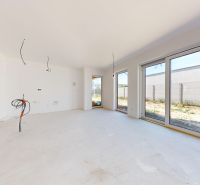 A bright interior of a family house with large windows and white walls.