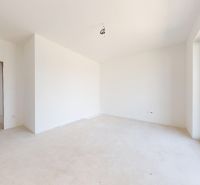 The interior of a family house with white walls and a large window.