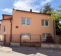 A family house on Mlynska Street in Piešťany with white windows, an orange facade, and a fence.