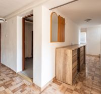 Interior of a family house with a cabinet and a mirror, floor with wooden decor.