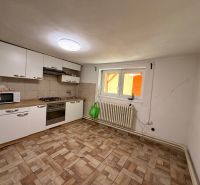 A kitchen in a family house with tiles and white cabinets.