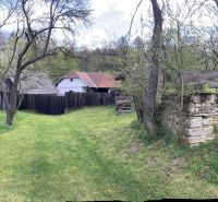 A family house in Bukovec surrounded by a green garden and trees.