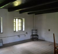 A room in a family house with a wooden decor floor and simple furniture.
