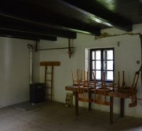 Interior of a family house with a stove, table, chairs, and a floor with a wooden decor.