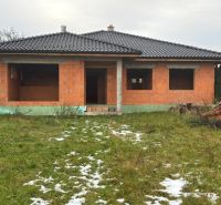 Unfinished family house in Dúbravka, with a black roof and empty windows, in a winter garden.