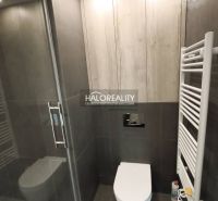 Bathroom sink cabinet in a studio apartment with wood decor and gray tiles.