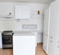 A kitchen in a family house with white cabinets and a wooden decor floor.