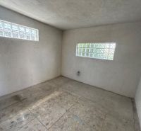 Empty room of a cabin with large glass blocks on two walls.