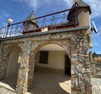 Stone cottage on Agátová Street in Šahy with arched arcades and iron railings.