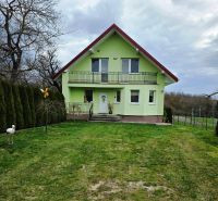 A green family house in Klokočov with a veranda and a landscaped garden.