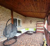The terrace of a family house in Klokočov with a hanging chair and wicker seating.