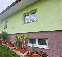 The facade of a family house in Klokočov with flower pots and landscaped greenery in the yard.