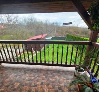 The balcony of a family house in Klokočov with a view of the garden and greenery.