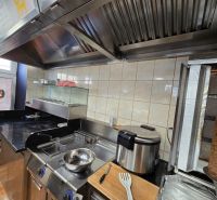 Kitchen equipment in gastro spaces with a grill and fryer for meal preparation.