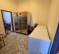 Cooling room with tiles in catering premises, containing a metal cabinet and a freezer.