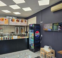 Gastro premises with the sale of drinks and food, floor with wooden decor, menu on the walls.
