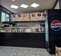 Gastro premises with a beverage offer, a Pepsi fridge, and tiles with ornaments.
