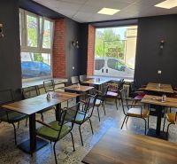 Gastro premises with brick walls, wooden tables, and tiled floors.