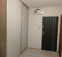A hallway in a 2-room apartment with a built-in wardrobe and shelves for storage.