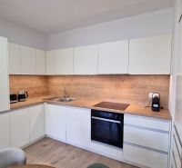 A kitchen in a 2-room apartment with a wooden decor and built-in appliances.