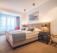 Recreational apartment with a comfortable bed, red armchair, and soft lighting.