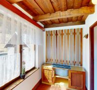 The interior of a family house with wooden decor and lace curtains on the windows.