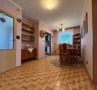 Dining room in a family house with a wooden decor floor and classic furnishings.